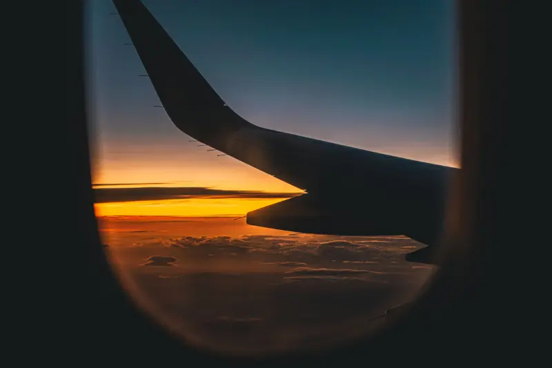 Ala di un aereo al tramonto vista dal finestrino