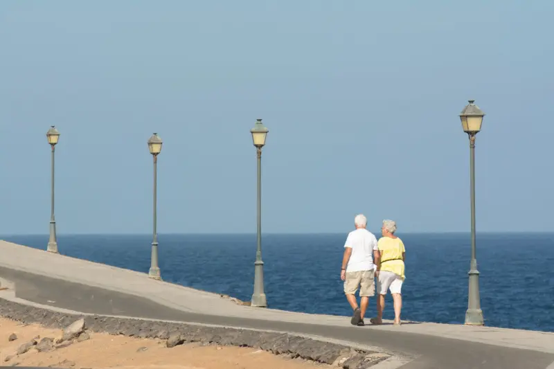 Coppia senior che cammina su un lungomare
