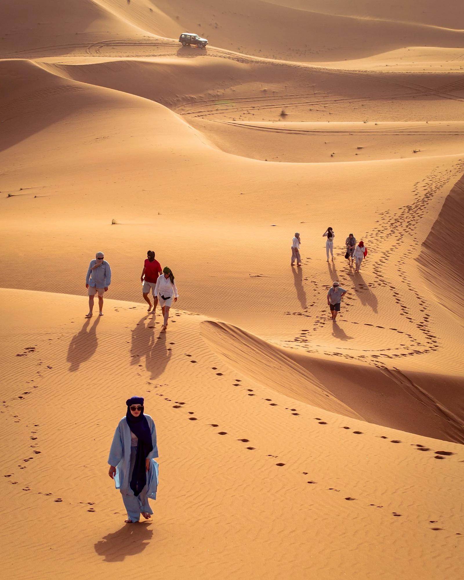 Viaggiatori con la guida tra le dune del deserto in Marocco